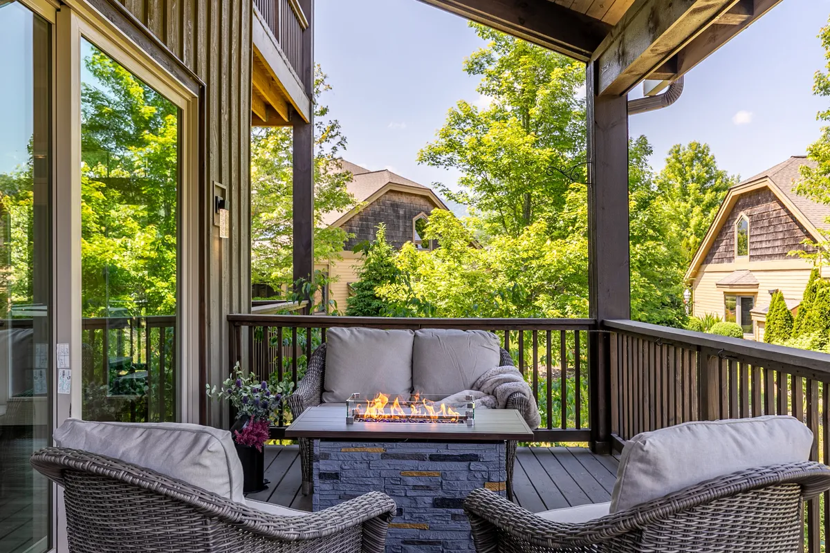 This image depicts an inviting outdoor fire pit area with comfortable seating surrounded by lush greenery. The cozy setting suggests the perfect spot for families and friends to gather in the evening, sharing stories or making s'mores under the open sky.