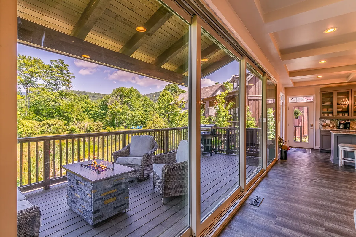 A cozy outdoor fire pit area with comfortable seating, set against a backdrop of mountain views and open sky. The scene is designed for social gatherings, with the fire pit as the central feature, perfect for enjoying sunset views and evenings by the fire.