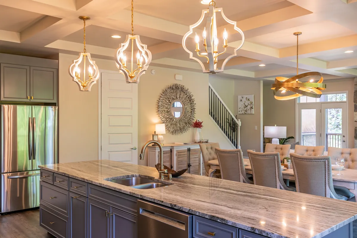 A spacious kitchen and dining area with a marble-topped island, elegant light fixtures, upholstered dining chairs, and a decorative mirror. The open layout and inviting atmosphere encourage gatherings and shared meals, making it a welcoming space for pet owners to feel at home.